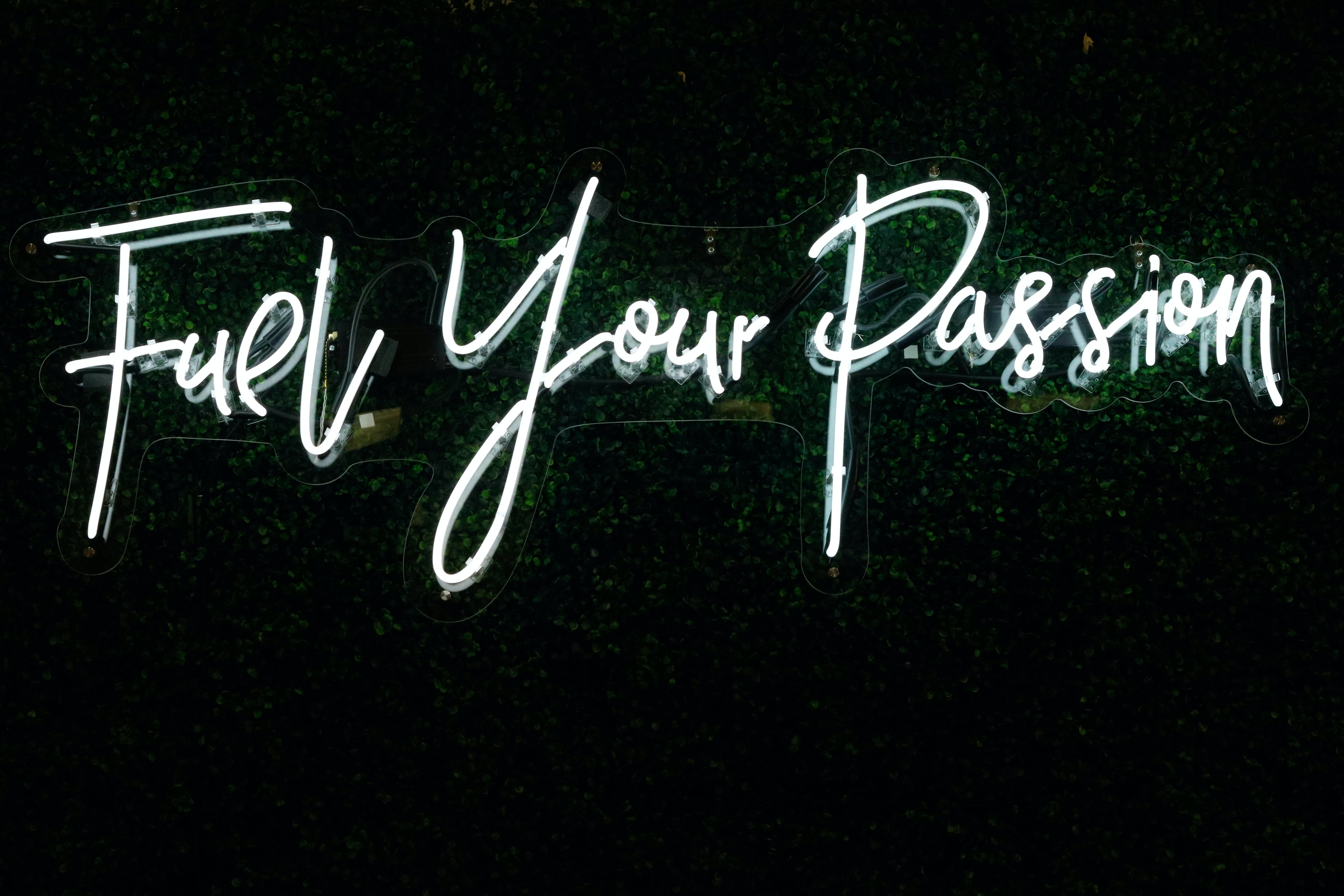 neon sign that reads Fuel Your Passion on a black wall