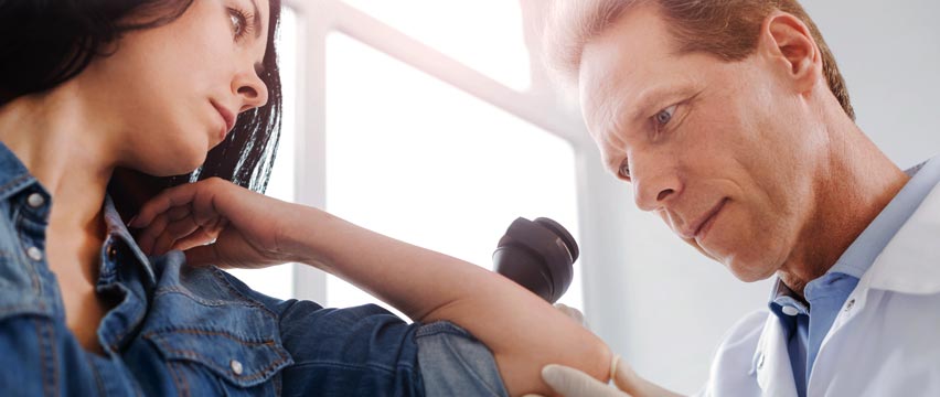 Dermatologist examing a patient's arm
