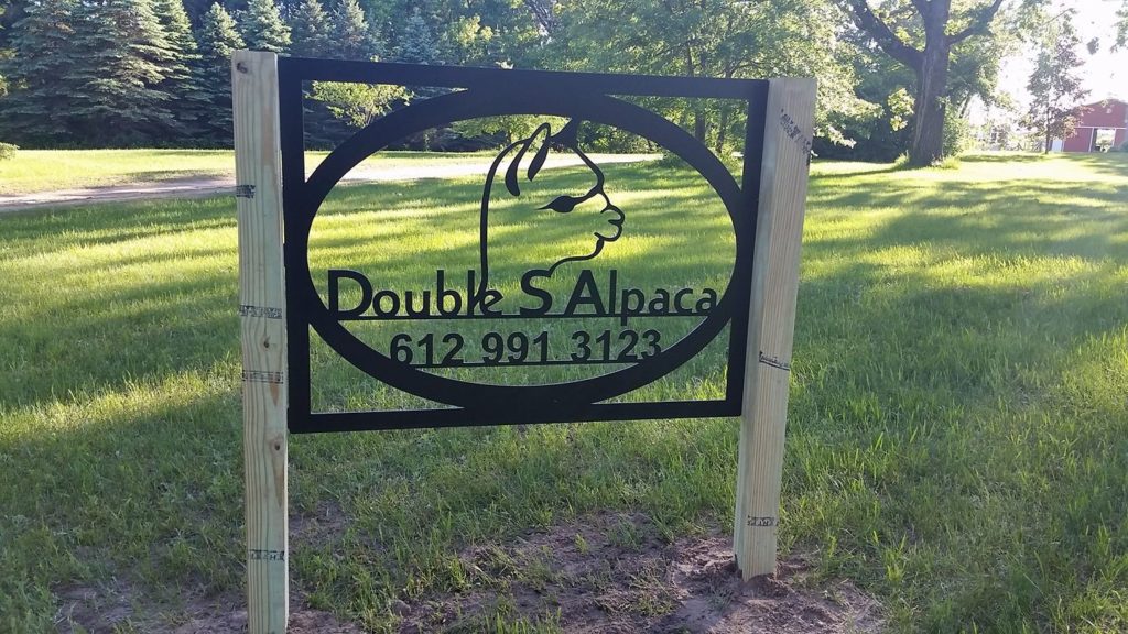 A sign for the Double S Alpaca Farm sits at the front of the property.