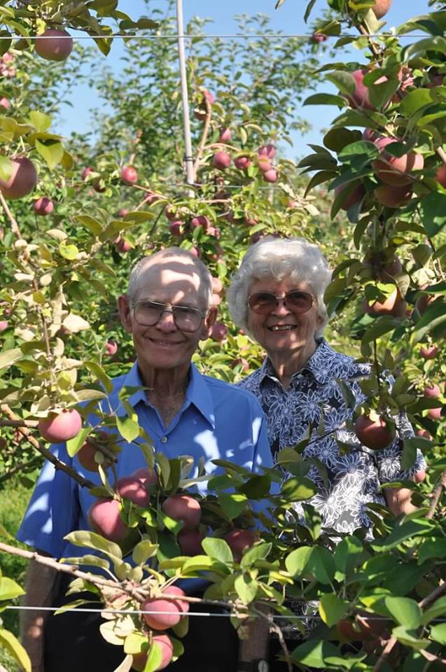 Windsor and Nancy Abbott posing in an apple orchard