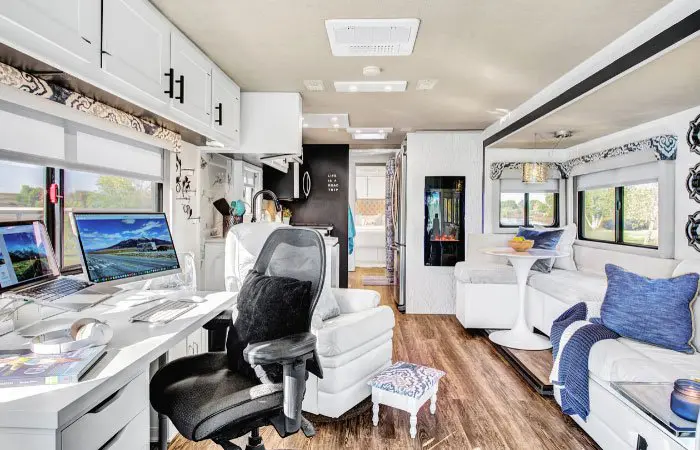 The inside of an RV after a remodel, with a dedicated desk and upgraded flooring