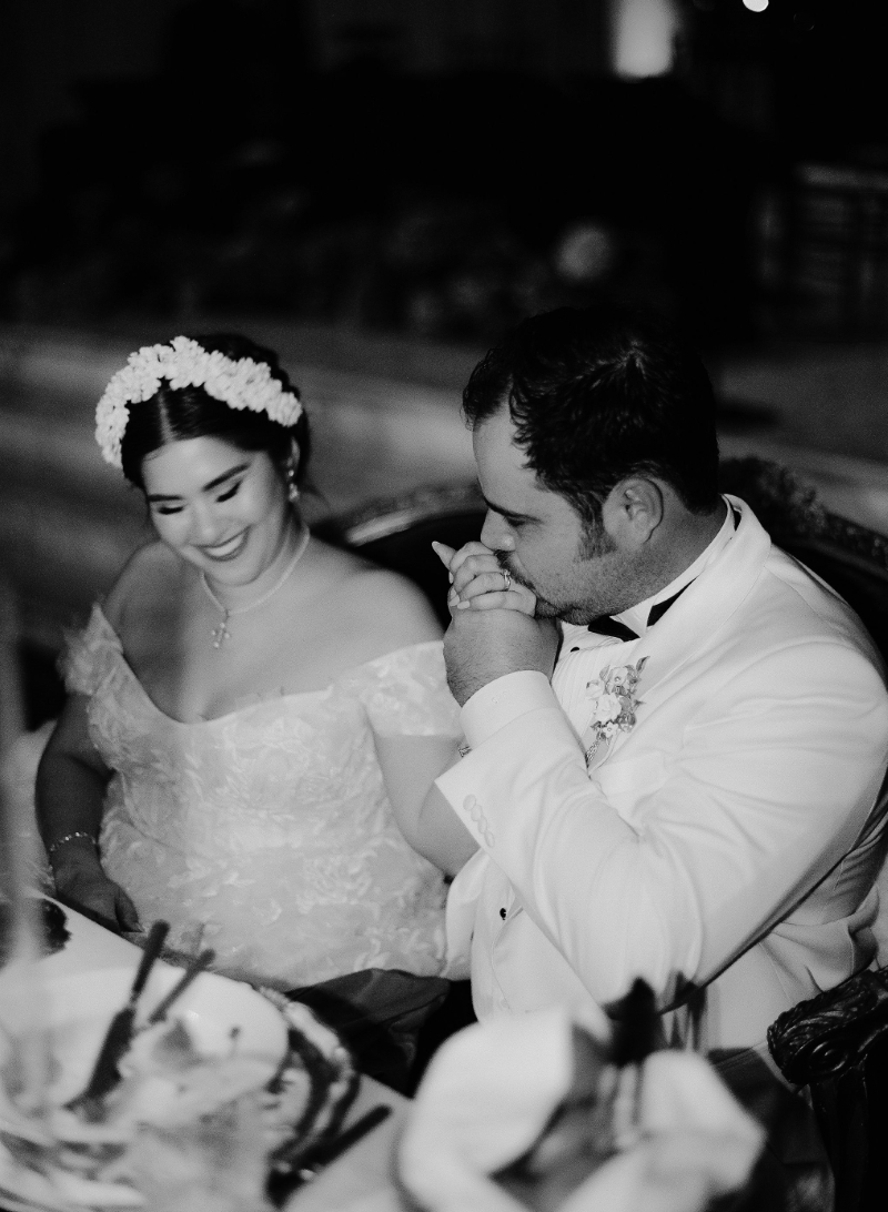 a groom kissing his bride's hand at their DTLA wedding sweetheart table