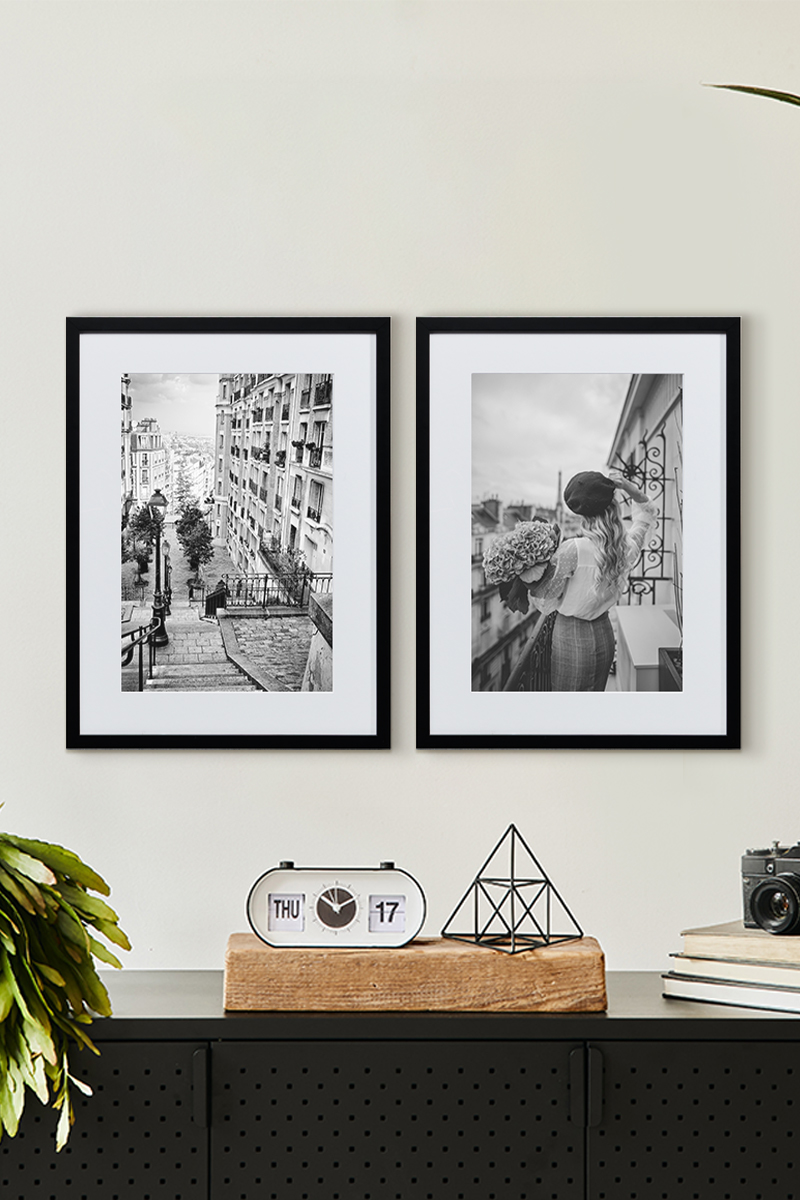 Black and white framed prints side by side on top of a table