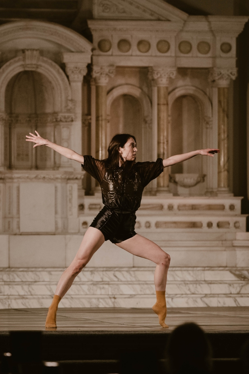 a dancer poses with her arm outstretched onstage at a performance at Vibiana in Downtown Los Angeles