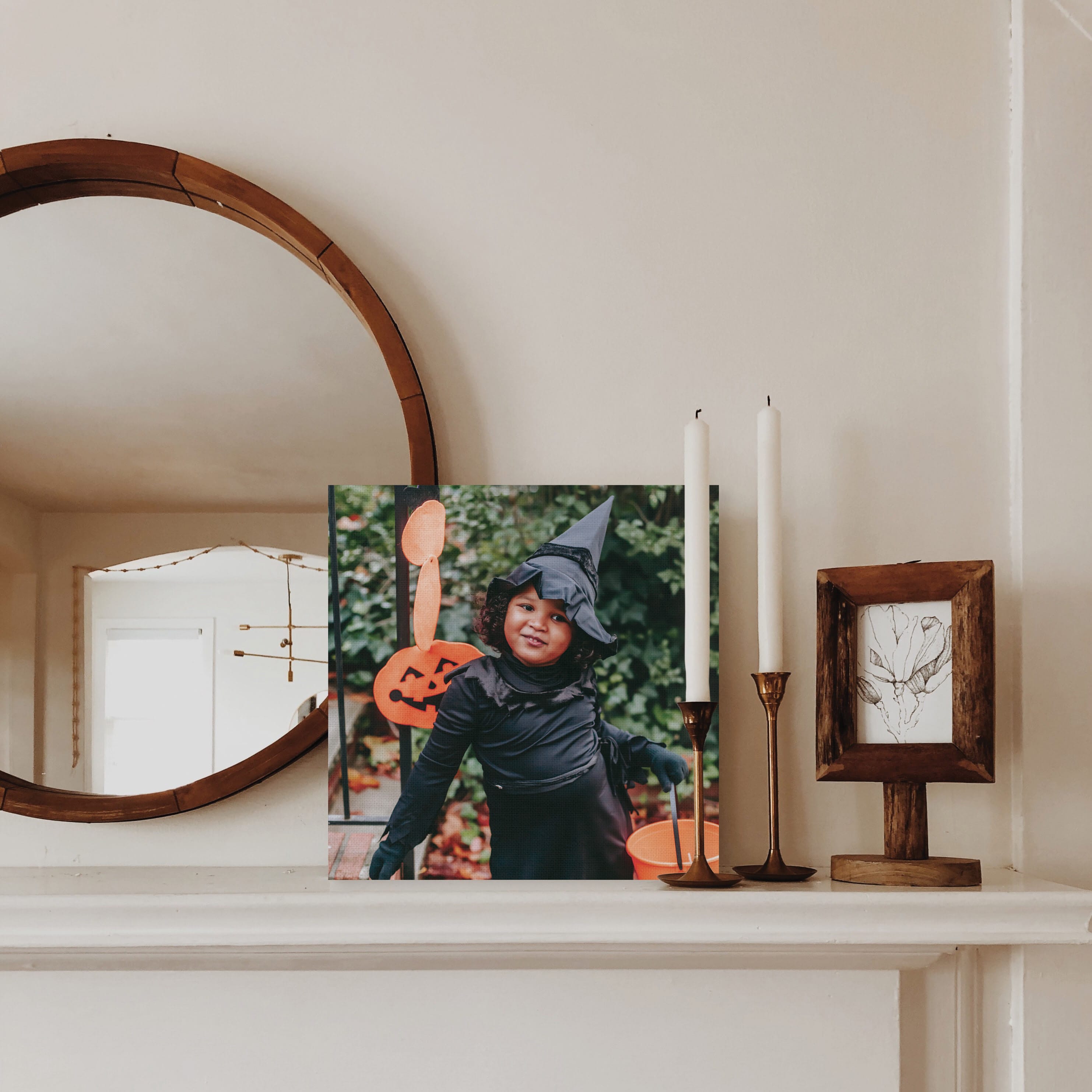 Canvas print on mantle of a little girl dressed up as a witch for Halloween