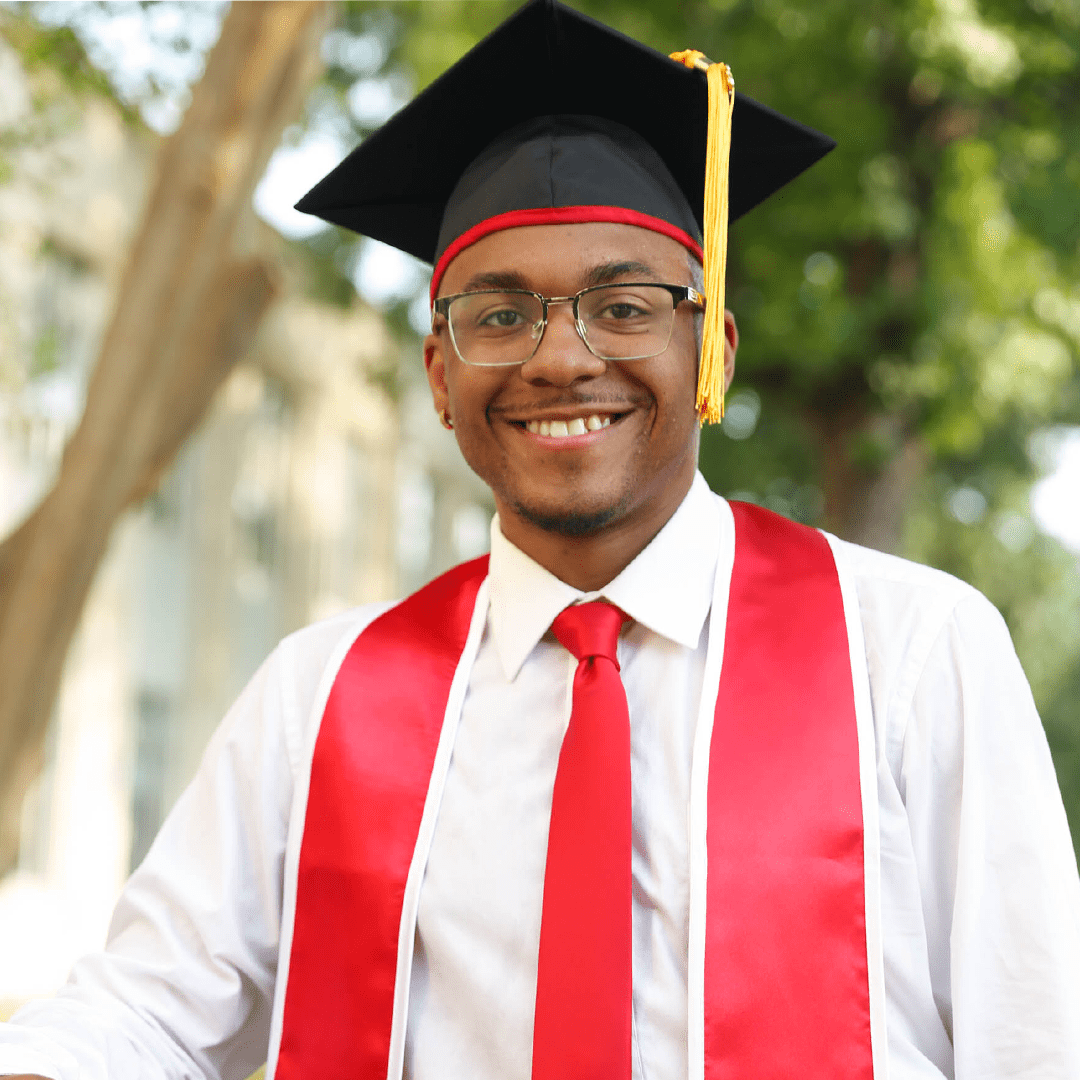 Picture of myself wearing graduation cap, a red stole, and red tie.