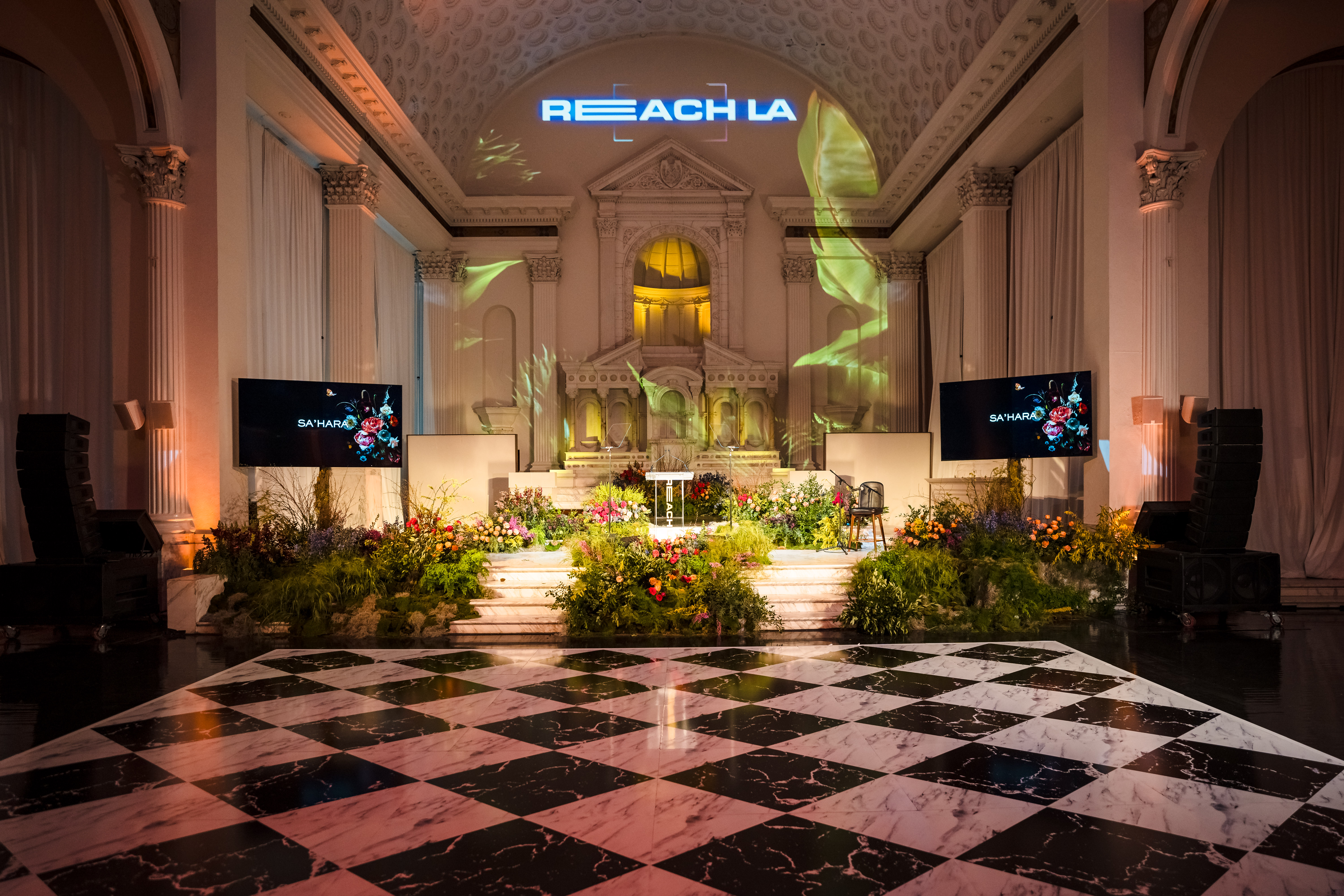 REACH LA gala at Vibiana with a checkered floor and flowers surrounding the altar in DTLA, photo taken by Villa Visuals