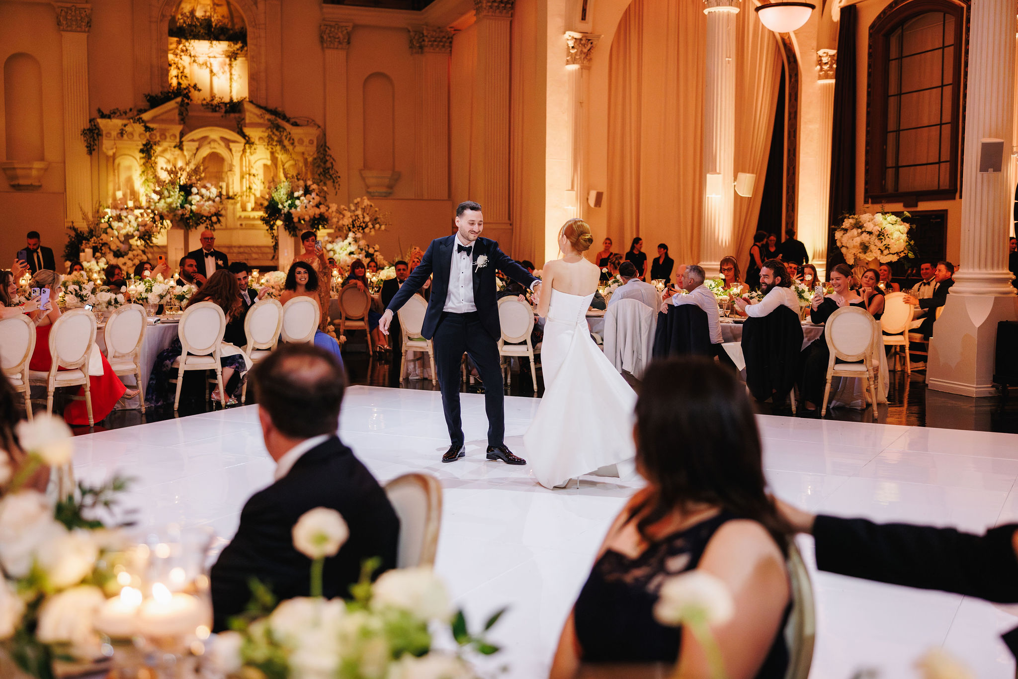 a bride and groom dance together in the middle of their wedding reception