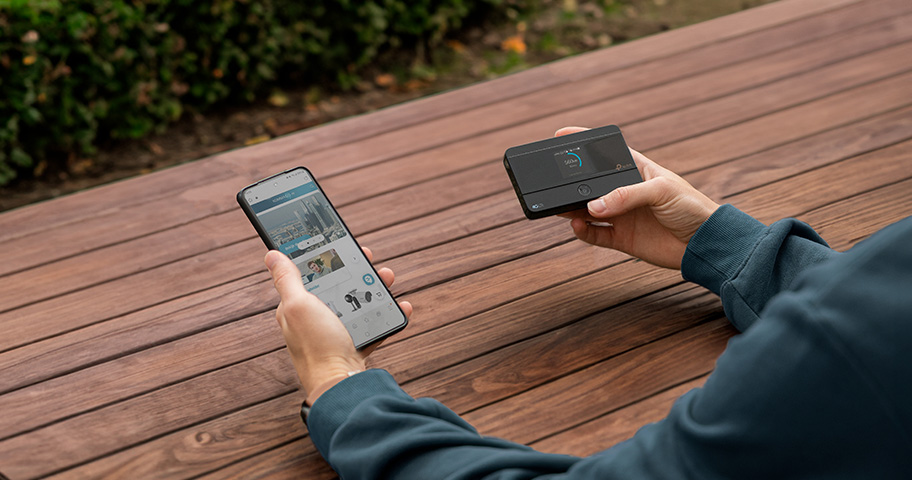 Iemand die een telefoon en een mifi router vasthoudt