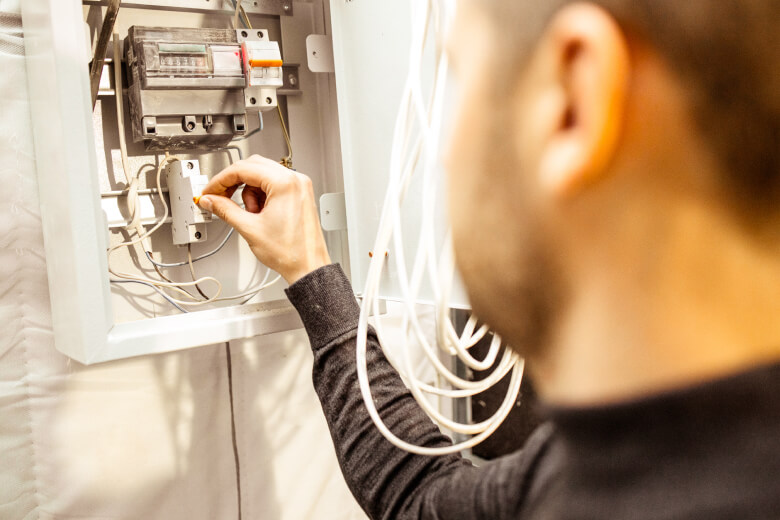 Electrician repairing electrical box and installing energy saving meter.