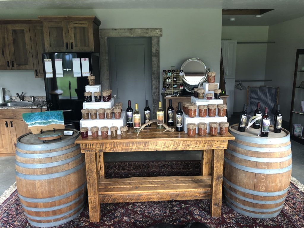 A gift shop sits filled with jams, syrups, and other homemade goods atop a barrel.
