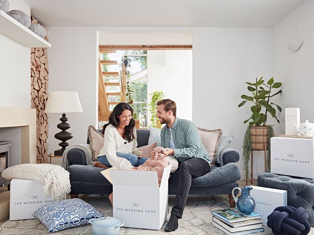 happy couple opening wedding gifts in home
