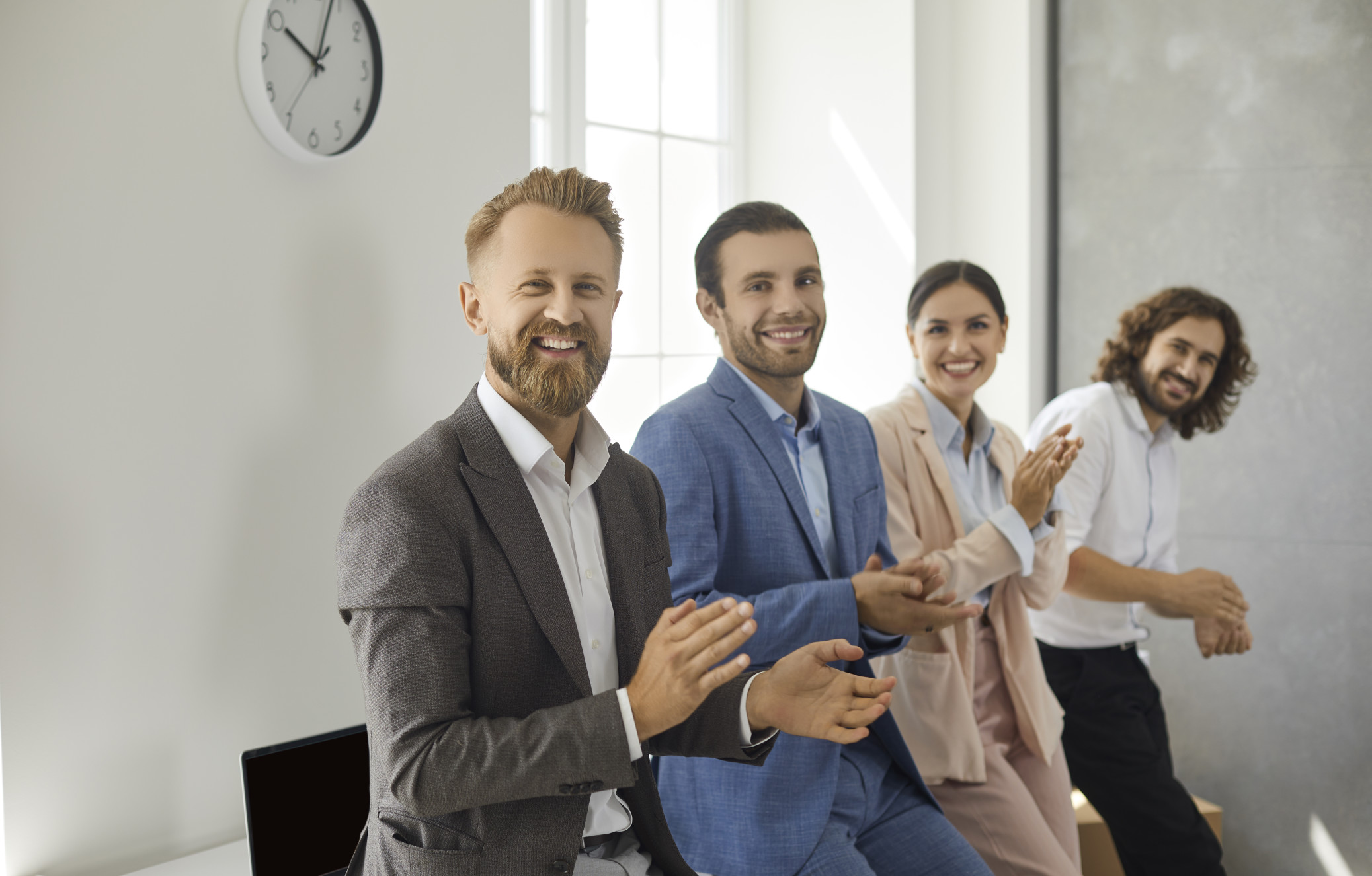 team-of-happy-business-people-standing-in-office-looking-at-camera-smiling-and-clapping-hands_t20_G7Jo6e.jpg