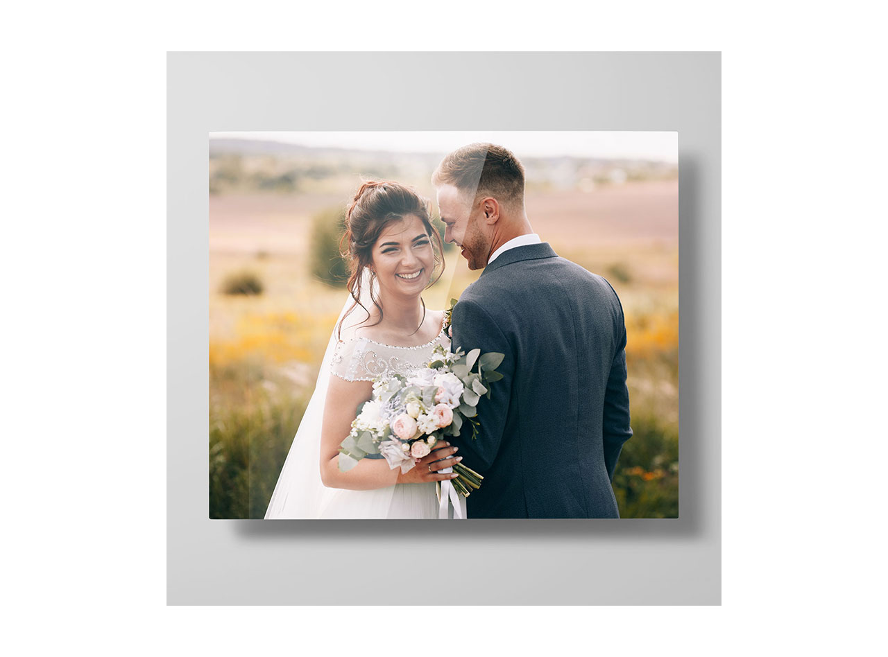 A metal print picturing a man and woman posing in a field on their wedding day