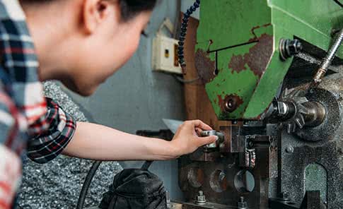 Manufacturing worker servicing heavy equipment