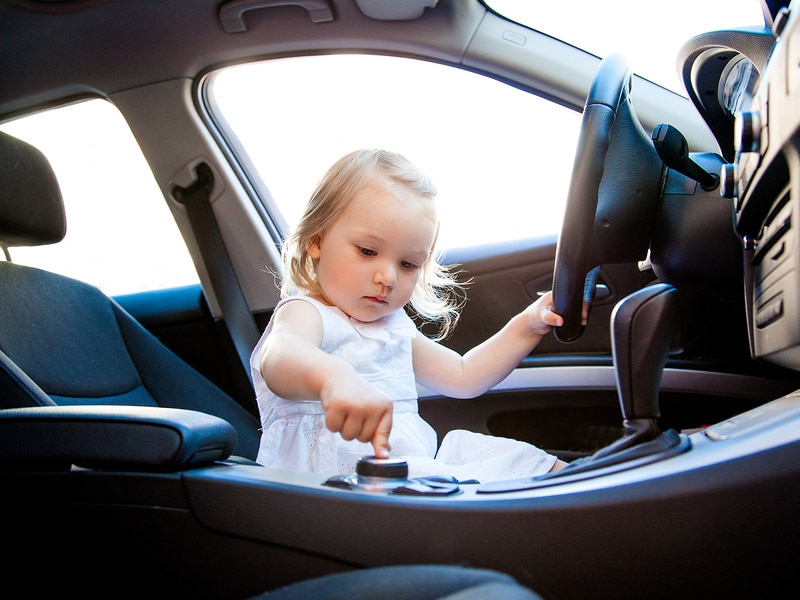 Child in car playing with controls 