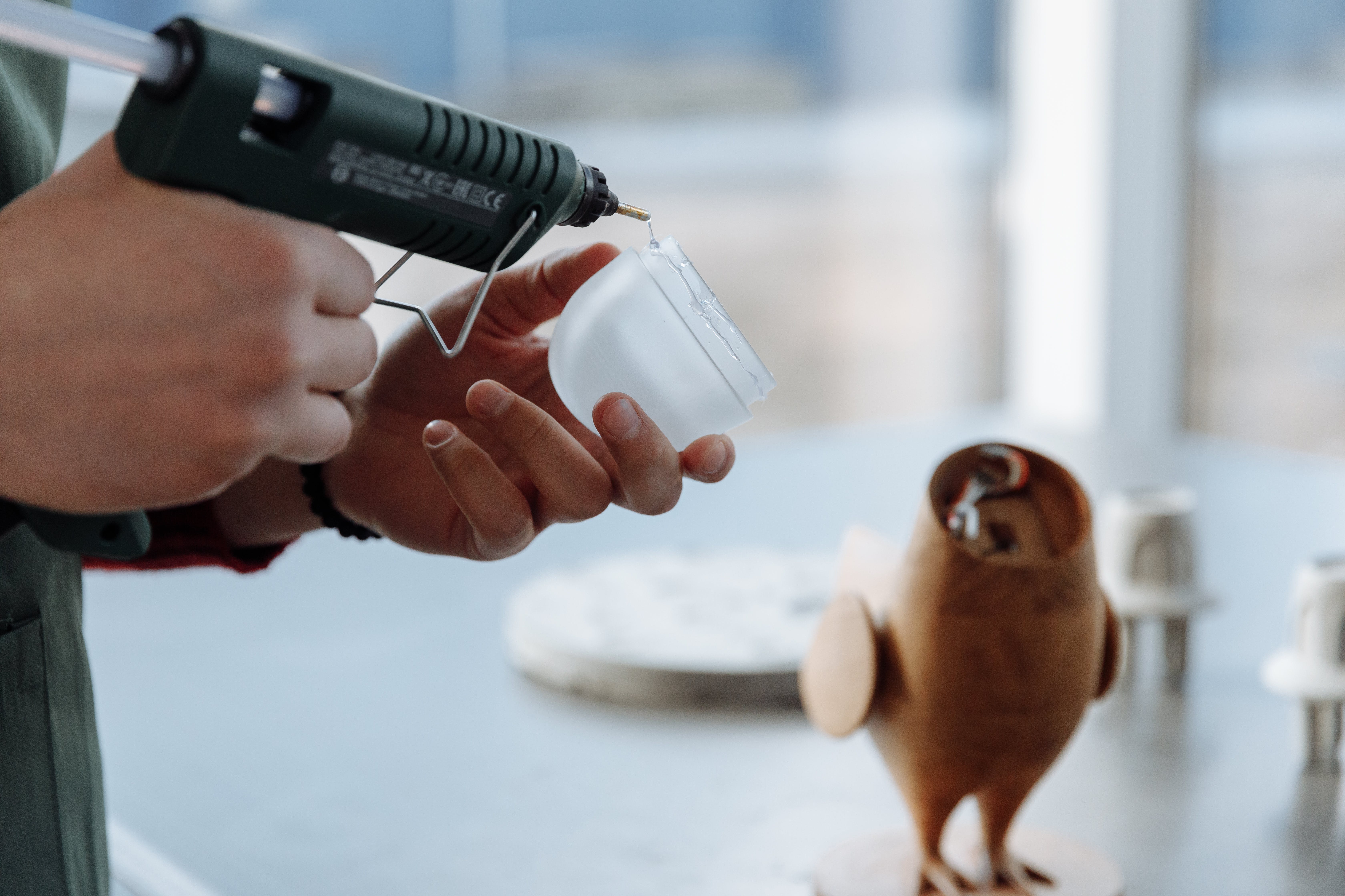 Person Putting Hot Glue on a Glass Dome Piece