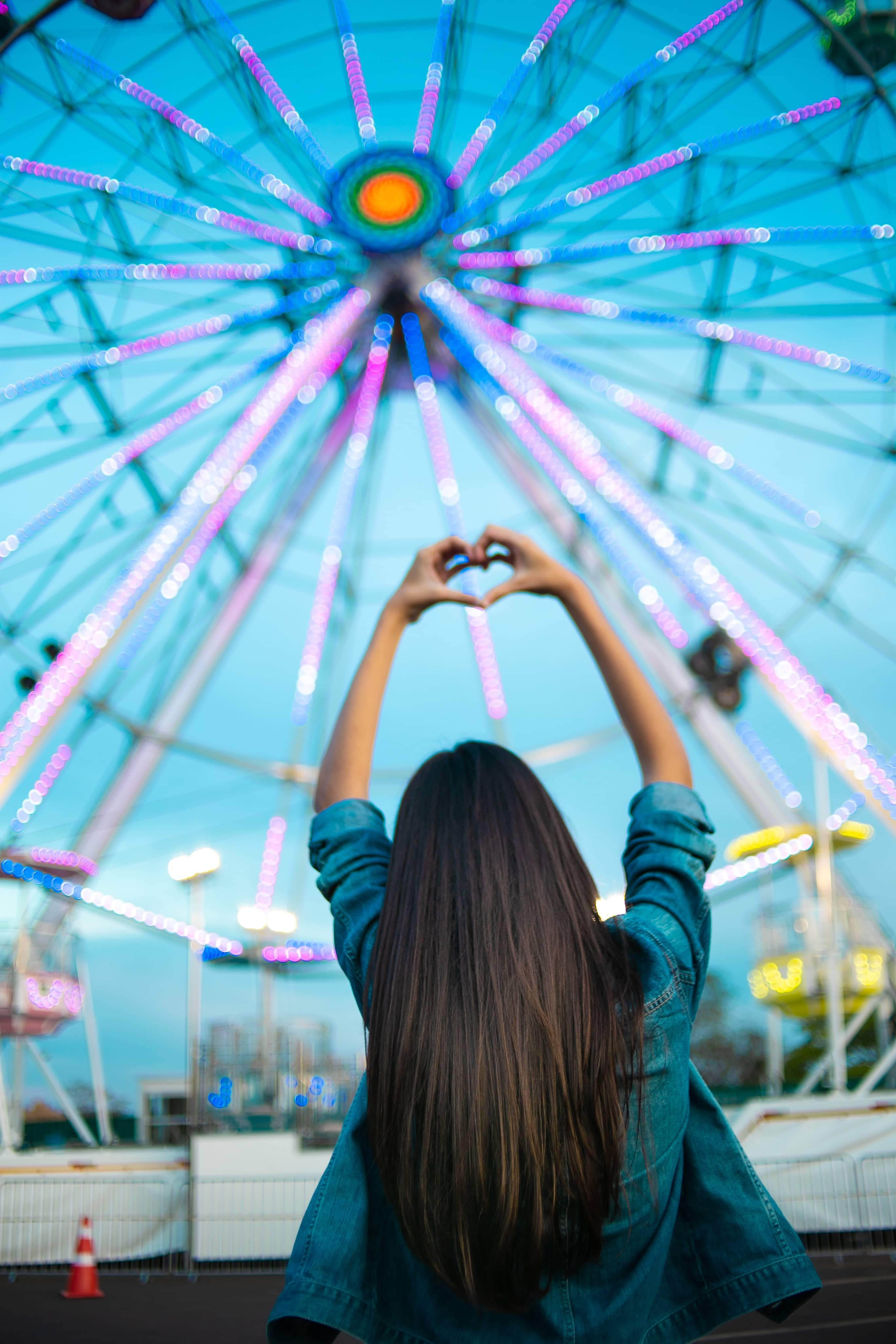 Girl posing in front of a ferris wheel