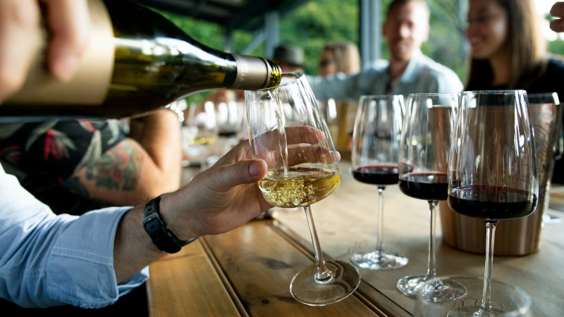 Pouring wine at table.