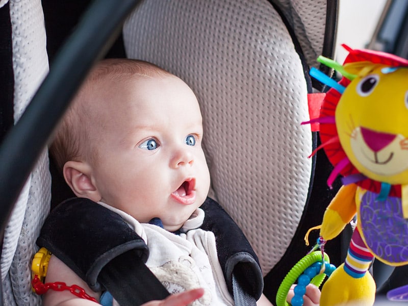 Baby in car seat with toy bar 
