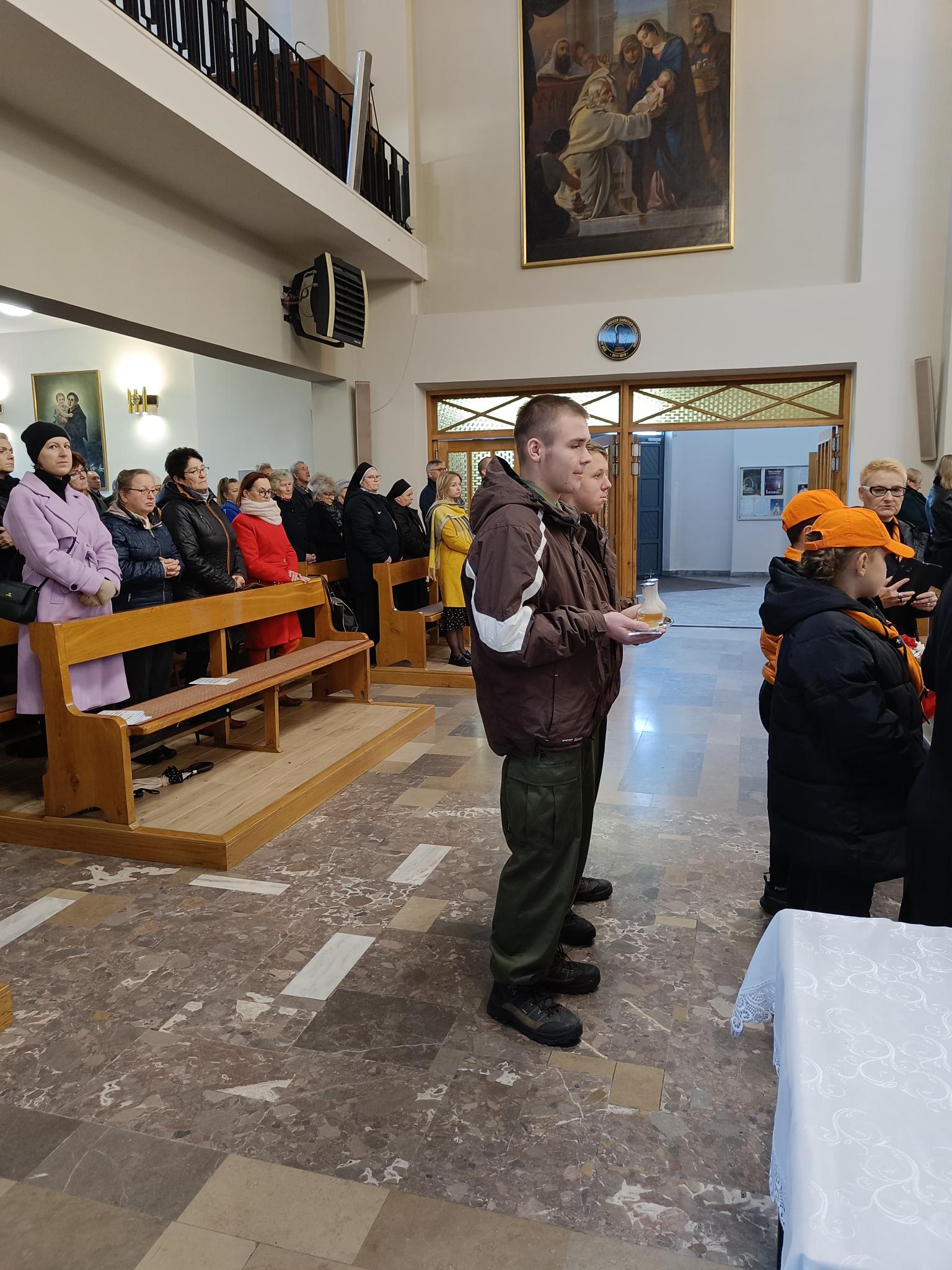 Narodowe Święto Niepodległości | Dwóch wychowanków MOW niesie ampułki w procesji z darami. W tle ławki z wirnymi, wnętrze kościoła..jpg