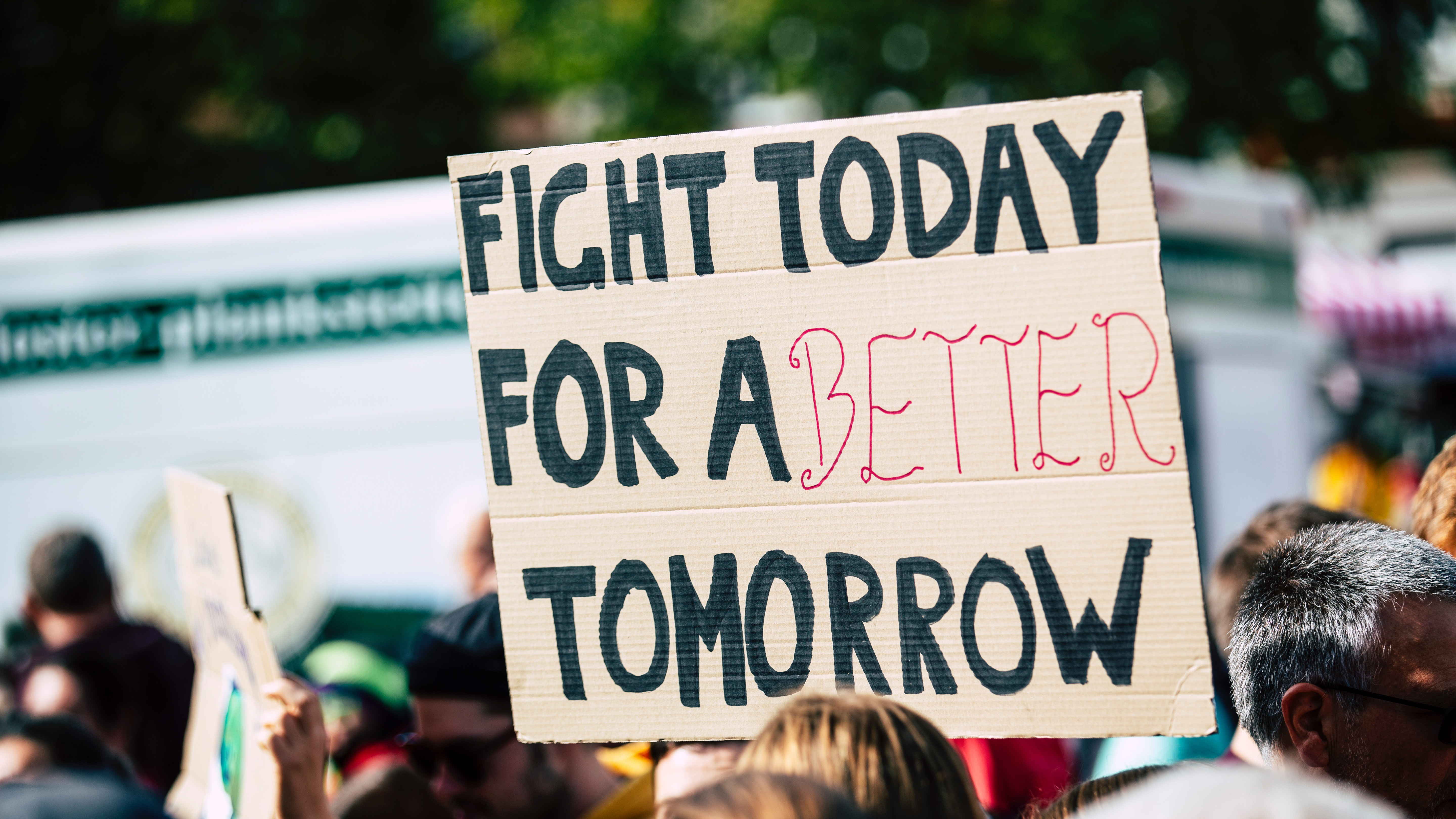 Bild von einer Demonstration. Auf einem Schild steht "Fight today for a better tomorrow"