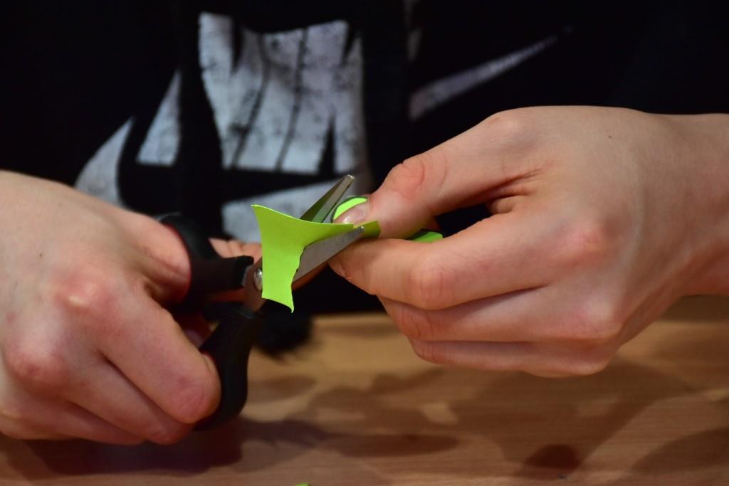 Dzień Św. Patryka  | Zbliżenie na ręce z nożyczkami podczas cięcia zielonego kartonu..JPG