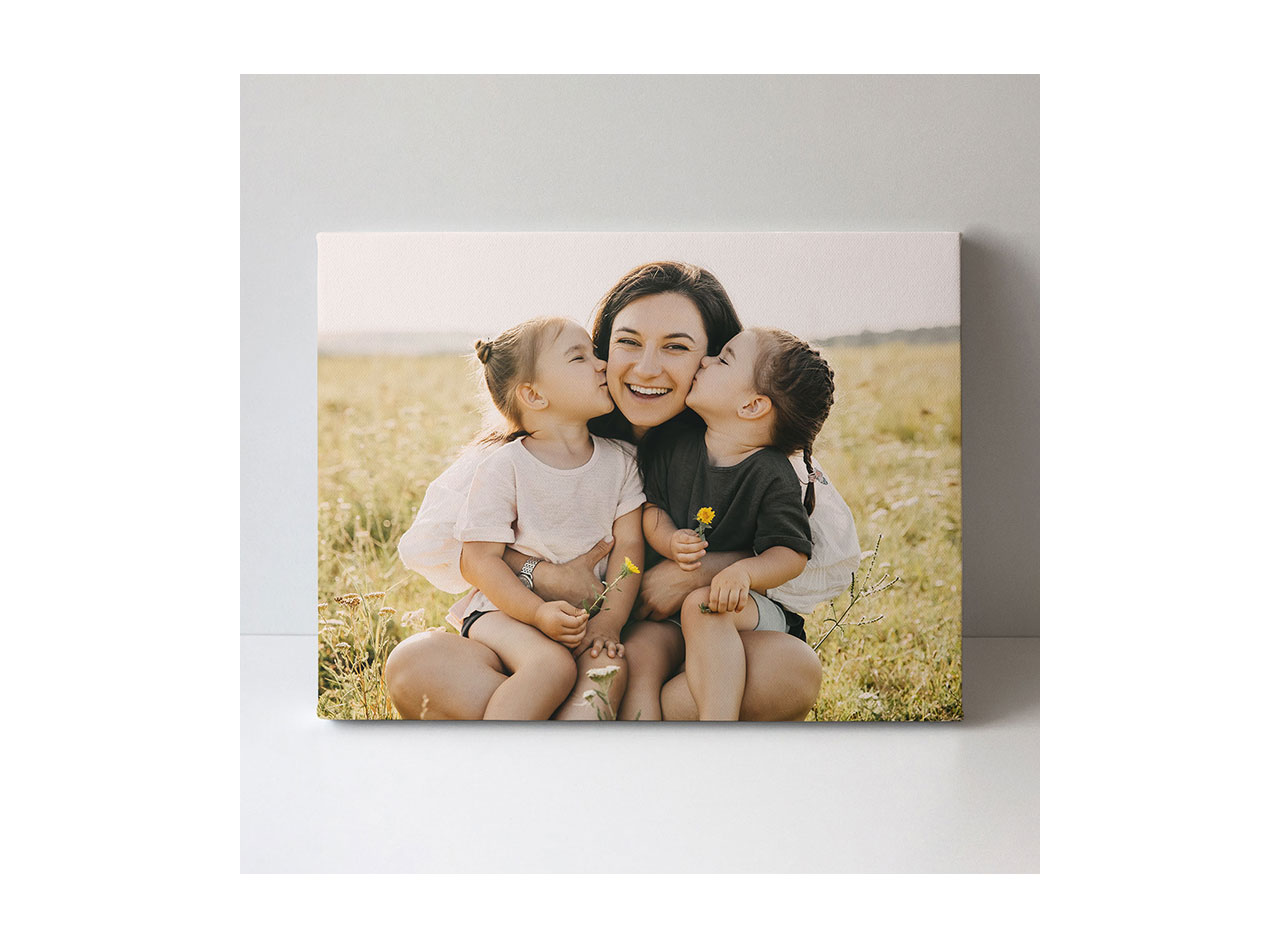  A canvas print showcasing a photo of a smiling mother and her daughters