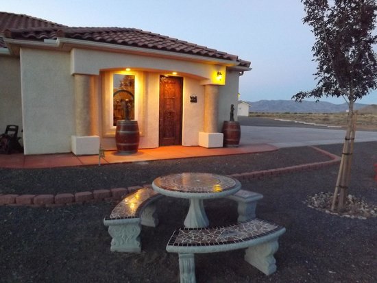 A dusk view of the front of the winery. The structure is white stucco with a red clay roof.
