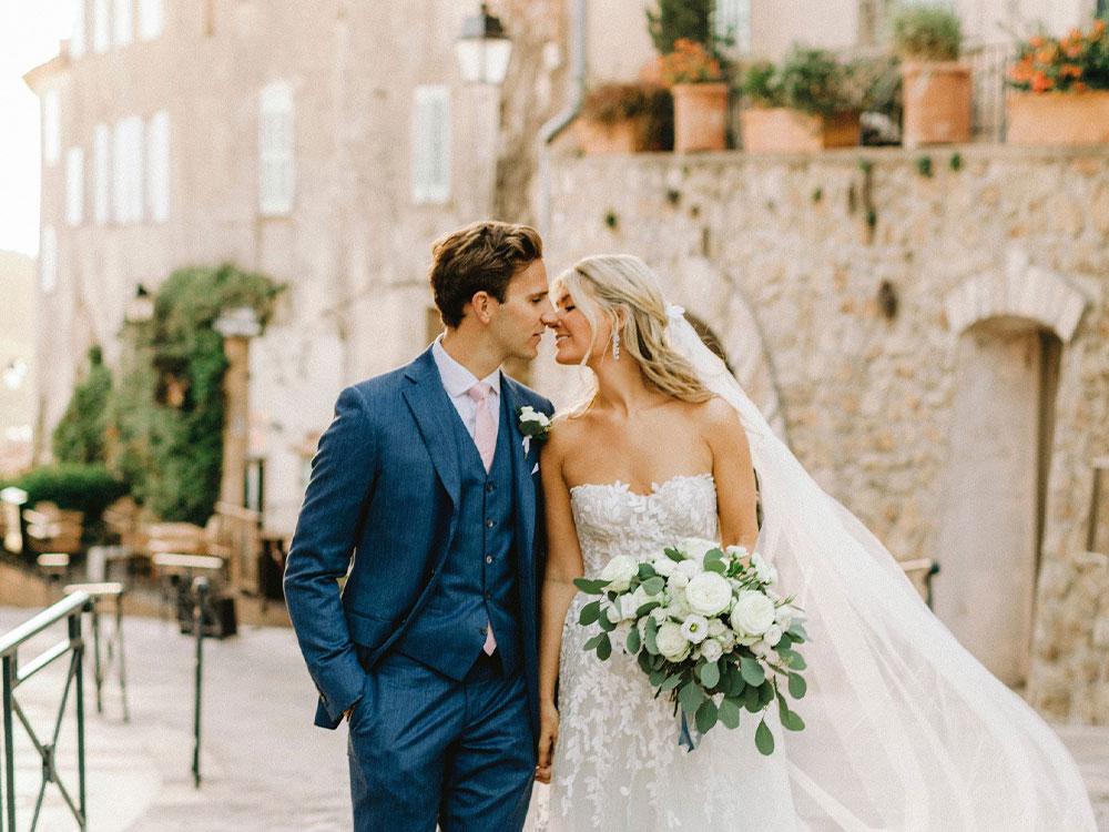 sequel wedding: bride and groom kissing in front of medieval wedding venue