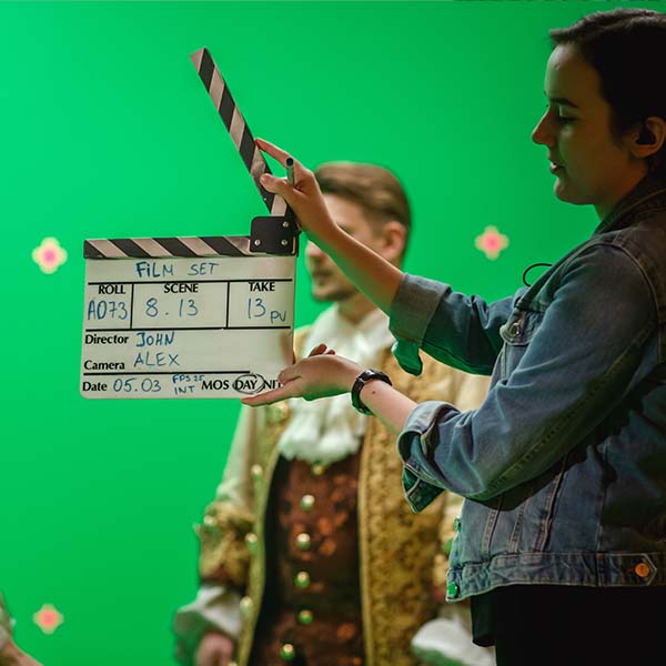 The second assistant camera (2nd AC) claps the clapboard on a film set