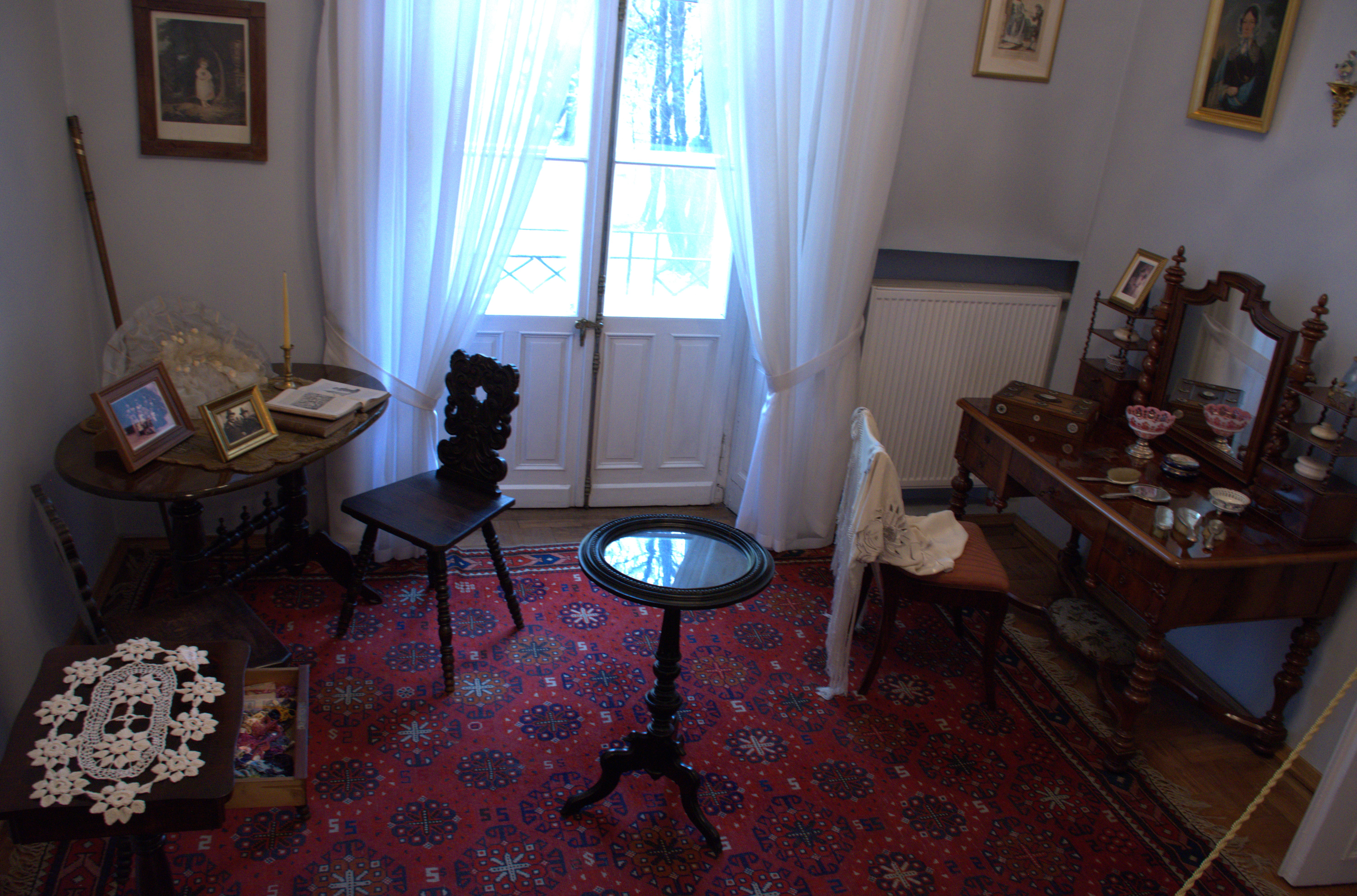 20 listopada - nasza wycieczka do Przeworska i Rzeszowa  | Przykładowy pokój z dawnej epoki. W kącie owalny stolik i drewniane krzesło, na środku okrągły stolik kawowy, po prawej drewniana toaletka z krzesłem. Na podłodze dywan..jpg