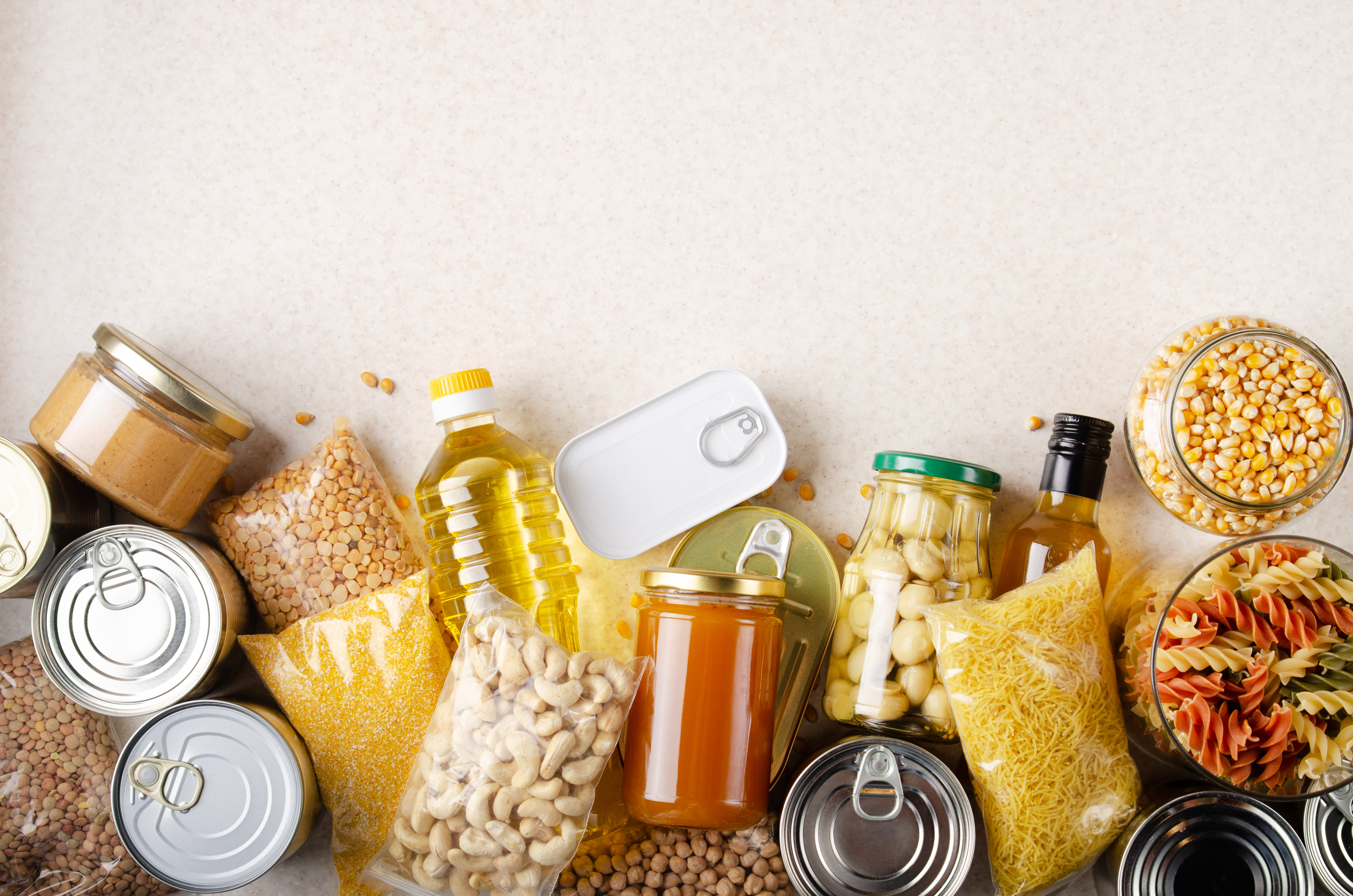 Flat lay view at kitchen table full with non-perishable foods