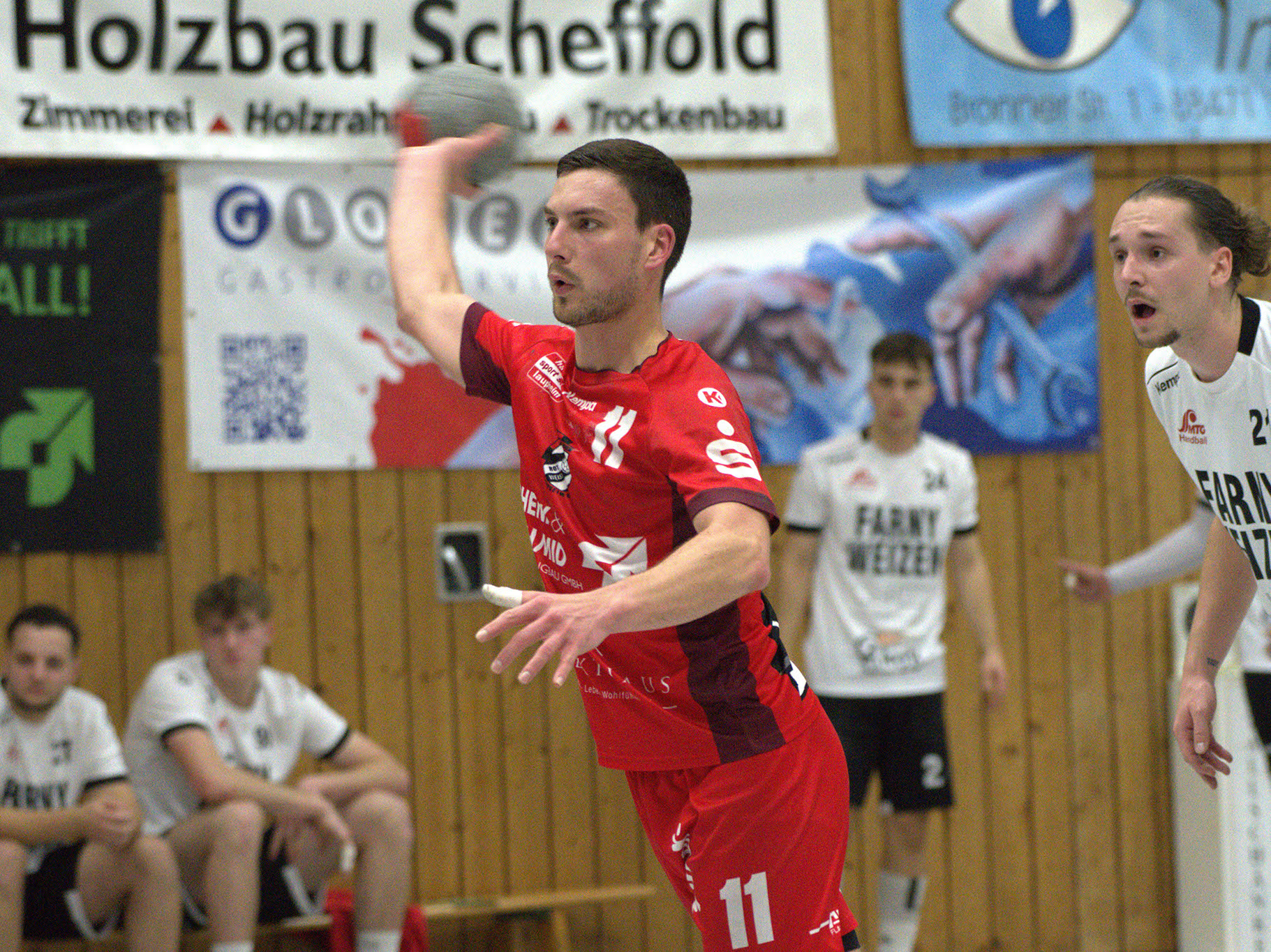 Handballspieler des HRW-Laupheim in rotem Trikot kurz vor dem Abwurf