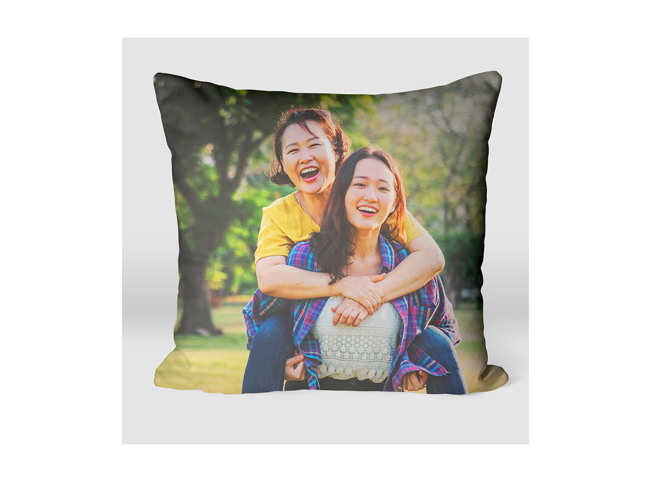 A photo pillow portraying a photo of a mother embracing her two daughters