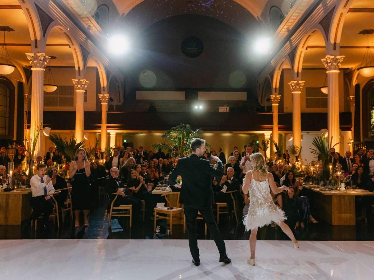 a bride and a groom perform a choreographed dance number together at their wedding reception in a cathedral in downtown Los Angeles on the dance floor