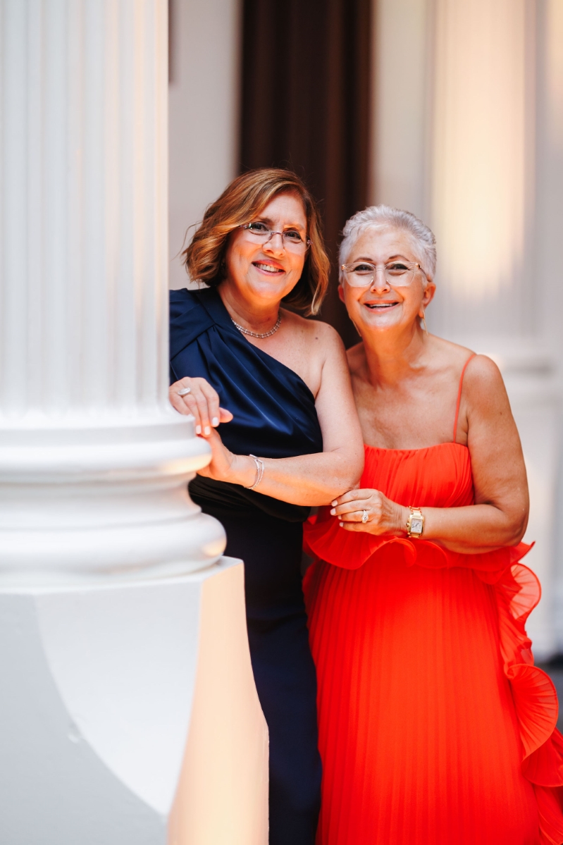 family members at a wedding reception pose together and smile at the camera