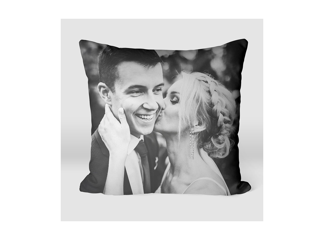 A pillow showcasing a black and white image of a couple on their wedding day