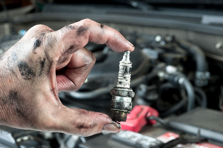 mechanic hold an old spark plug 