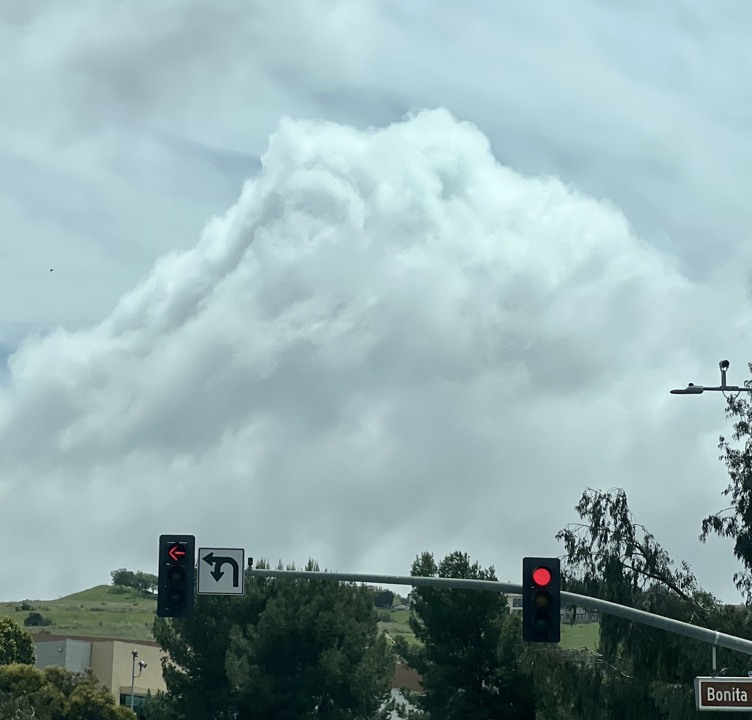 Wide shot with traffic lights in the bottom foreground with a very cloudy and overcast sky in the background