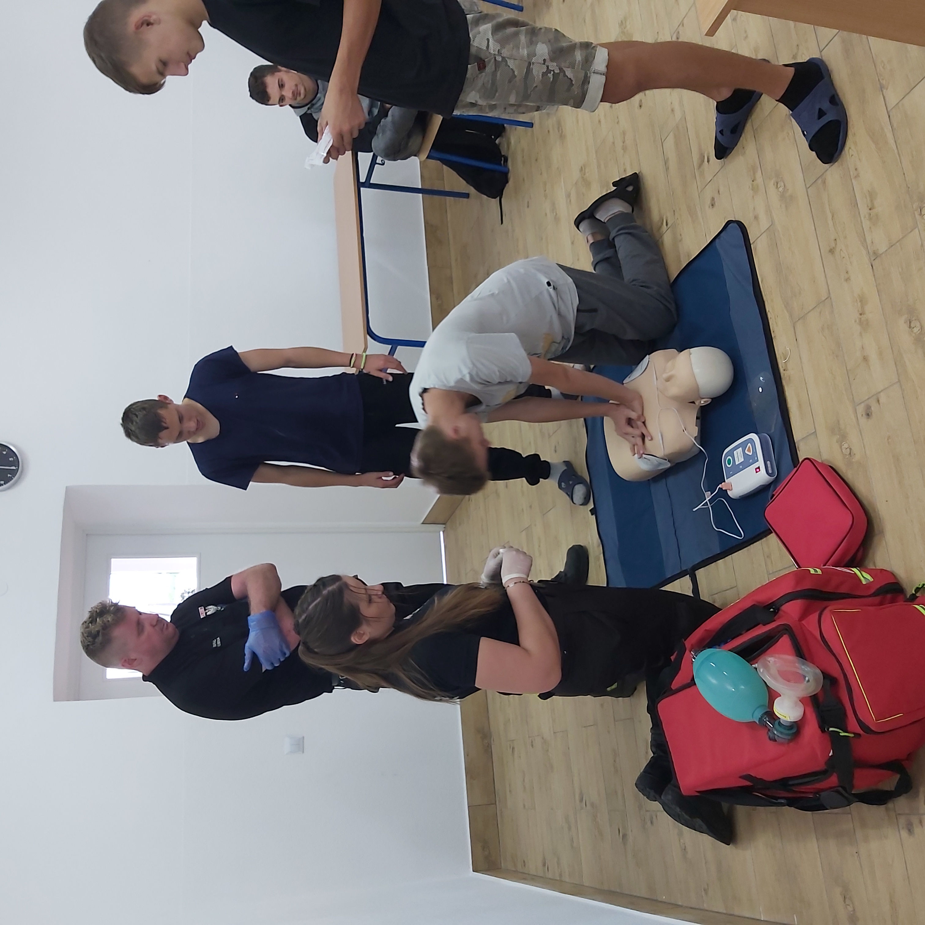 Warsztaty z pomocy przedmedycznej | Wychowanek MOW ćwiczy na manekinie masaż serca, obok stoją przypatrujący się wychowankowie oraz Druhowie sprawdzający poprawność wykonania masażu..jpg