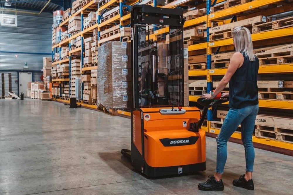 Woman with Doosan forklift in warehouse