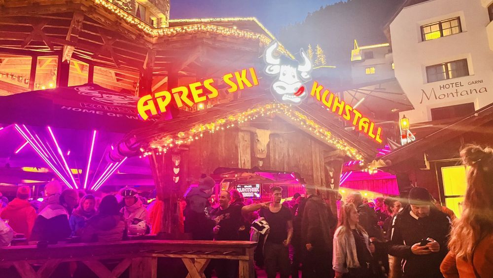Shot of the après-ski party location "Kuhstall". You can see lots of people and bright, colorful light.