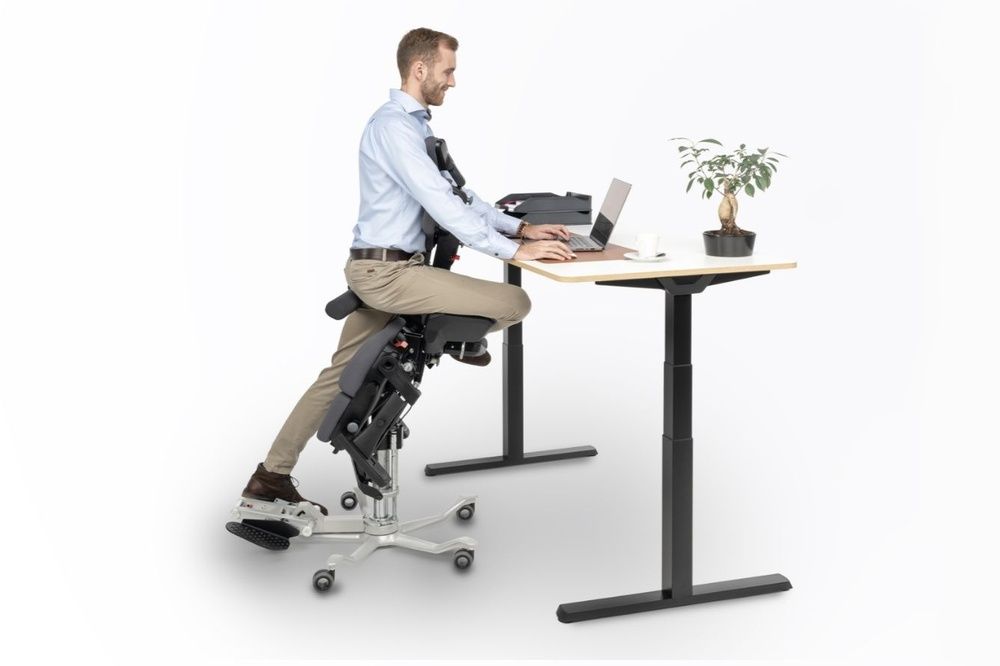 Man sits ergonomically at his desk