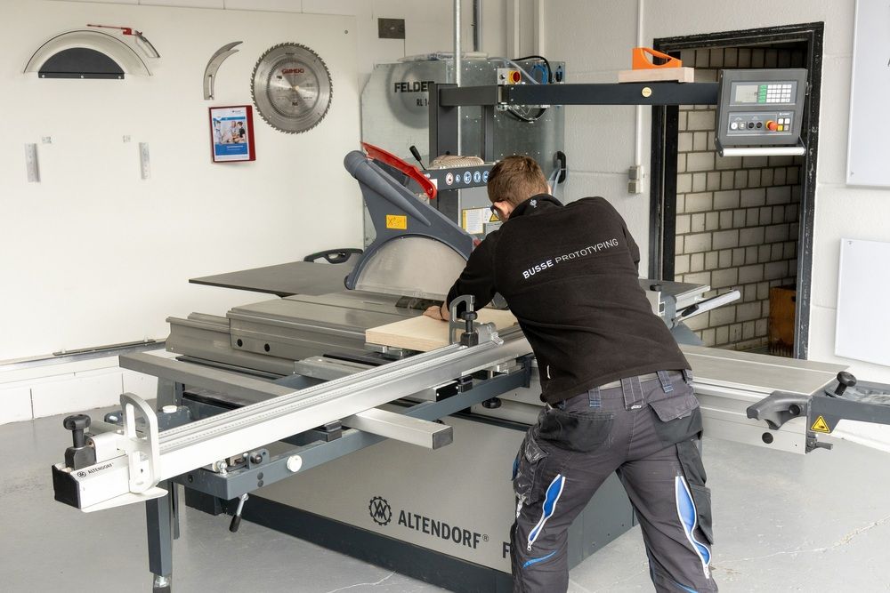 A man is seen from behind operating a circular saw.