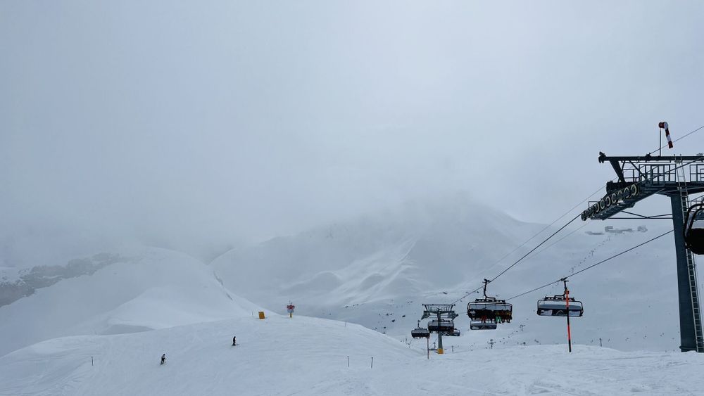 Schneebedeckte Pistenlandschaft mit Ski-Lift auf der rechten Seite.