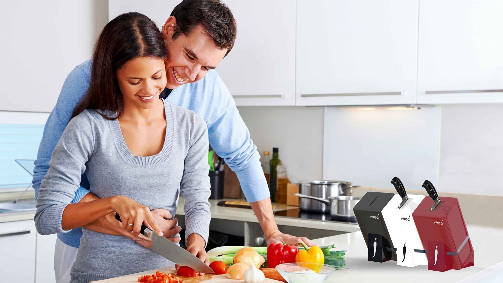 Mann und Frau schneiden gemeinsam Gemüse mit dem Sked Messer