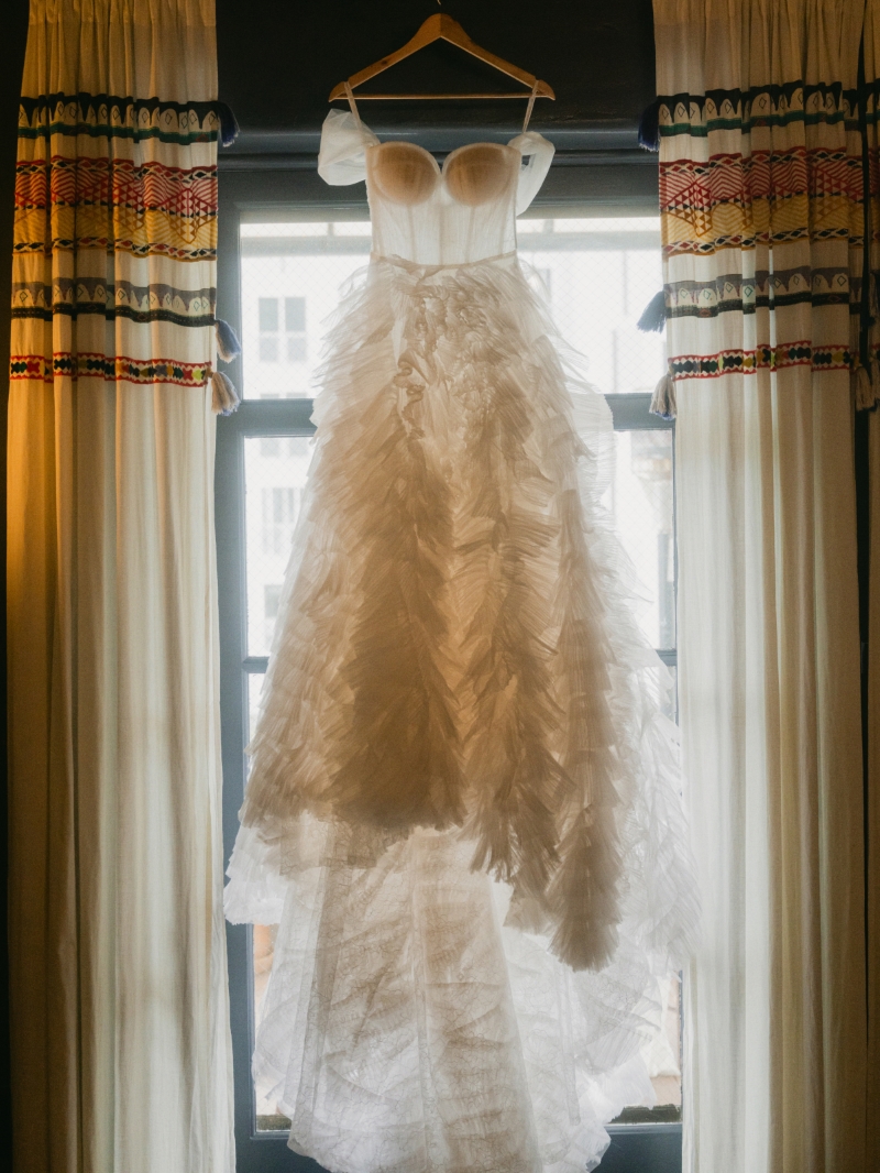 a wedding dress hanging in front of a window for DTLA wedding