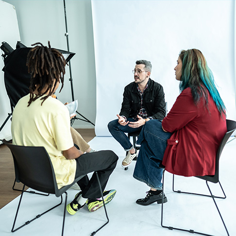 A group of people talking to a Wellbeing Facilitator on set