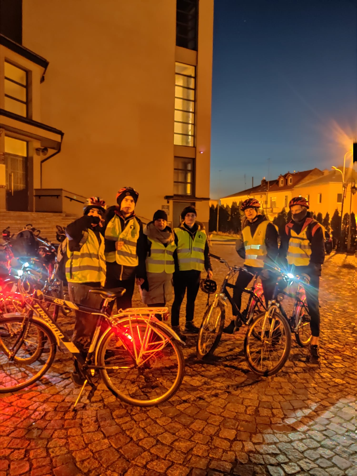 Rowerowa Droga Krzyżowa | Wychowankowie MOW z opiekunami stoją na brukowanym dziedzińcu kościoła. Przed nimi stoją rowery.jpg